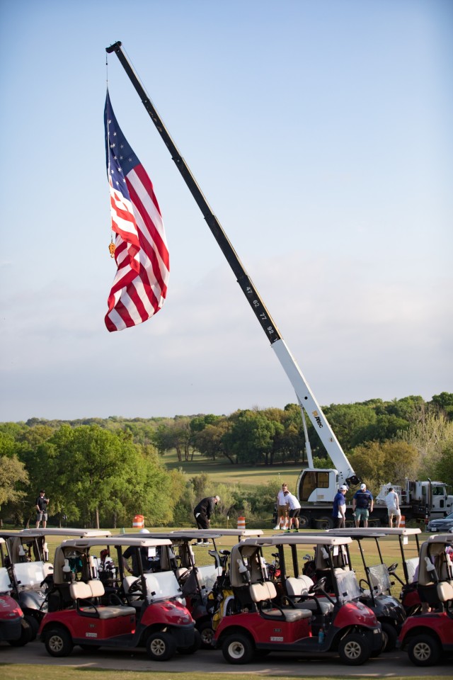 A large American flag blows in the wind as golfers warm up for the Ben Hogan Classic March 31 at Fort Hood, Texas. (U.S. Army photo by Blair Dupre, Fort Hood Public Affairs)