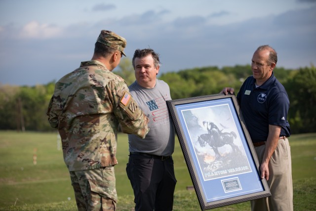 Lt. Gen. Sean Bernabe, III Armored Corps and Fort Hood commanding general, presents Judd Pritchard, CEO of the Ben Hogan Foundation, with a special gift March 31 at Fort Hood, Texas. (U.S. Army photo by Blair Dupre, Fort Hood Public Affairs)