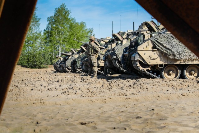 U.S. Soldiers assigned to the 1st Battalion, 8th Infantry Regiment, 3rd Armored Brigade Combat Team, 4th Infantry Division, arrive on their assigned M2A3 Bradley fighting vehicles prior to live demolition training as part of Defender 22 at Oberlausitz Training Area, Germany, May 10, 2022.