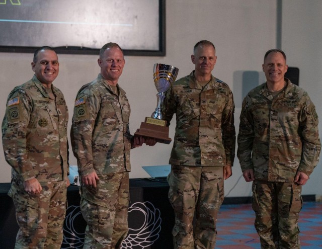 Left to right, Command Sgt. Maj. Randolph Delapena, the senior enlisted advisor of the 82nd Airborne Division, Command Sgt. Maj Calvin Overway, the senior enlisted advisor of 1st Brigade, 82nd Airborne Division, Col. Theodore Kleisner, commander of 1st Brigade, 82nd Airborne Division, and Major Gen. Christopher LaNeve, commander of the 82nd Airborne Division, pose with the Innovation Cup at the 82nd Airborne Division Innovation’s first Innovation Drop Zone Competition on Fort Bragg, N.C., March 29, 2023. 1st Brigade’s submission to the Innovation Drop Zone Competition won the competition, and until the next iteration, 1st Brigade Combat Team will maintain ownership of the cup.