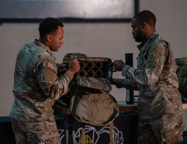Left to right, Pfc. John Drake and Sgt. Kylan Mack, Paratroopers assigned to 2-325 Airborne Infantry Regiment, present the “Lunchbox” 60mm Mortar Round Carrier at the 82nd Airborne Division Innovation’s first Innovation Drop Zone Competition on Fort Bragg, N.C., March 29, 2023. The round carrier was designed to help preserve the integrity of multiple rounds through a variety of weather conditions and decrease the time required to conduct a fire mission. 