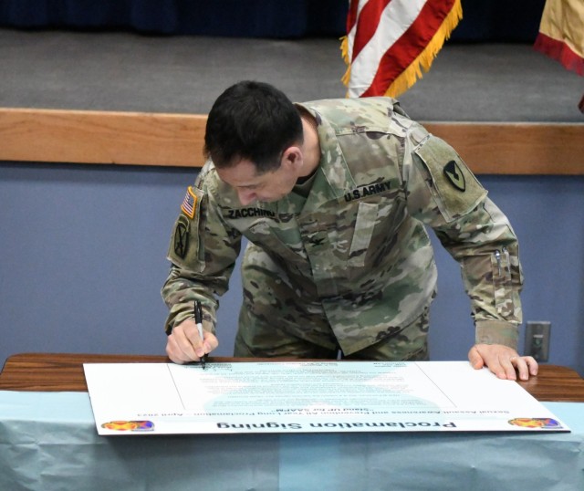 Col. James Zacchino Jr., Fort Drum garrison commander, signs the Sexual Assault Awareness and Prevention Month proclamation April 11 during a town hall meeting attended by civilian employees. (Photo by Mike Strasser, Fort Drum Garrison Public Affairs)