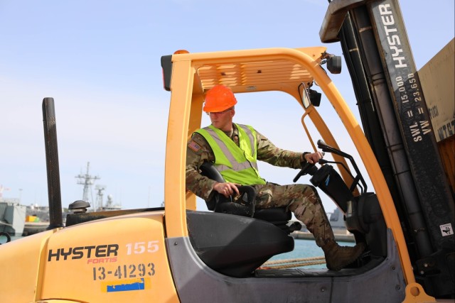 U.S. Army Sgt. Nick Suits, hazmat non-commissioned officer, 5th Battalion, 159th Aviation Regiment, 244th Expeditionary Combat Aviation Brigade, operates a forklift to offload equipment container for Defender 23 at Naval Station Rota, Spain, April 6, 2023.
