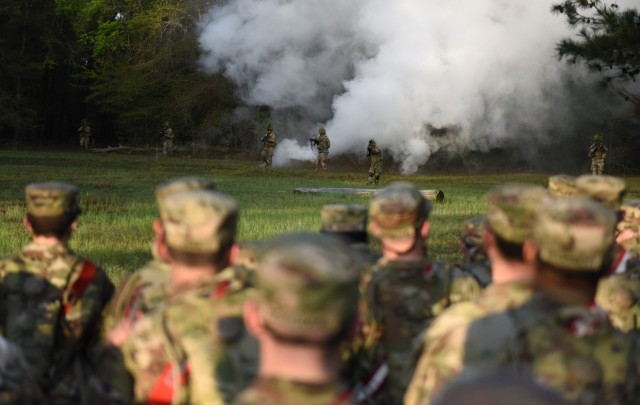 Infantry recruits with Bravo Company, 1st Battalion, 50th Infantry Regiment, observe the Hooah squad during the First 100 Yards at Fort Benning, Georgia, March 30, 2023. The 90-minute event teaches new recruits how to quickly work together to accomplish the mission. 
