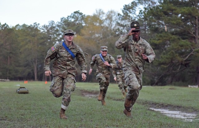 Infantry recruits with Bravo Company, 1st Battalion, 50th Infantry Regiment, compete in medical-evacuation race during the First 100 Yards at Fort Benning, Georgia, March 30, 2023. The 90-minute event teaches new recruits how to quickly work together to accomplish the mission. 