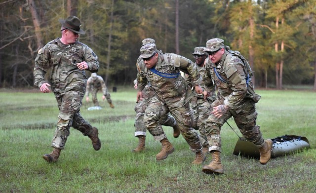 Infantry recruits with Bravo Company, 1st Battalion, 50th Infantry Regiment, compete in a medical-evacuation race during the First 100 Yards at Fort Benning, Georgia, March 30, 2023. The 90-minute event teaches new recruits how to quickly work together to accomplish the mission. 