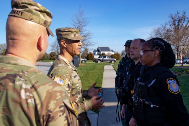 Maj. Gen. Robert Edmonson II and Sgt. Maj. Michael Conaty pin teal badges on APG police