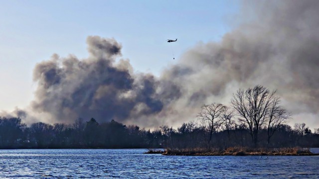 A Wisconsin Army National Guard UH-60 Black Hawk helicopter from the Madison-based Army Aviation Support Facility #2 carries a bucket of water to help fight a fire near Necedah in Juneau County April 12, 2023. The Wisconsin National Guard...