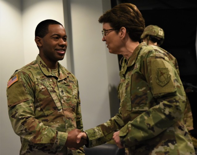 Sgt. 1st Class Alonte Washington, senior movement manger in the Transportation Readiness Directorate, receives a coin for excellence from Air Force Gen. Jacqueline Van Ovost, commander of U.S Transportation Command, April 10, at Rock Island Arsenal, Illinois.