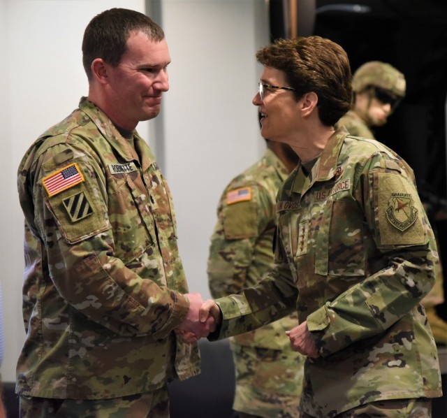Lt. Col. Steven Robinette, Lead Material Integration Directorate executive officer, receives a coin for excellence from Air Force Gen. Jacqueline Van Ovost, commander of U.S Transportation Command, April 10, at Rock Island Arsenal, Illinois.