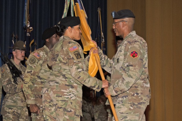 Col. Fredrick Parker, 3rd Chemical Brigade commander (right), passes the unit guidon to incoming Command Sgt. Maj. Kiana Bell during a change-of-responsibility ceremony on Tuesday in Baker Theater. Outgoing 3rd Chem. Bde. Command Sgt. Maj. Joe...