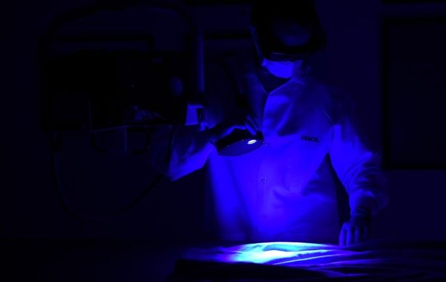 Amelia Bussell-Martinez, USACIL forensic biologist, performs an alternate light source demonstration during a laboratory visit March 28 in Forest Park, Georgia. The lab provides criminal investigators from every military branch with 24 forensic services ranging from DNA testing to latent print and trace evidence analysis.  