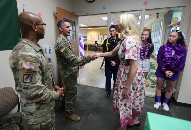 Kentucky First Lady Britainy Beshear is greeted by Fort Knox Garrison Commander Col. Lance O’Bryan and Command Sgt. Maj. Sherman Waters upon her arrival to Fort Knox Middle High School April 21, 2023 for Purple Up Day honoring the Month of the Military Child.