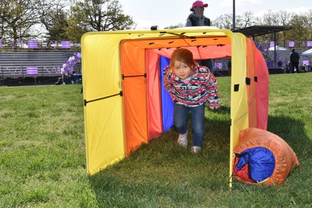 Four-year-old Evalena Hall makes her way through the final tunnel of an obstacle course at the Month of the Military Child Palooza Saturday on Gerlach Field.