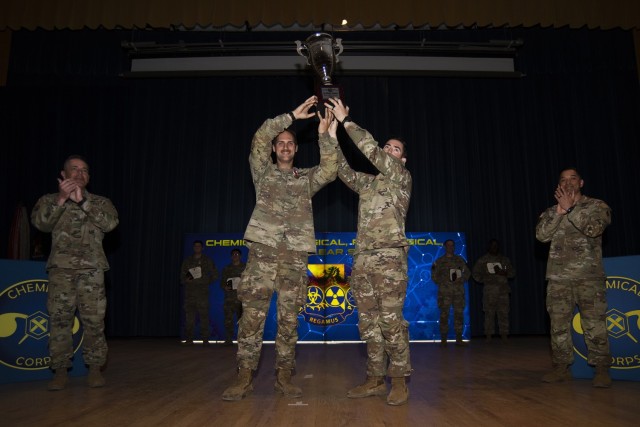 1st Lt. Connor Macky and Staff Sgt. Joseph Feola, with the 95th Chemical, Biological, Radiological and Nuclear Company at Joint Base Elmendorf-Richardson, Alaska, hold up the trophy on Friday at Baker Theater, after being named the winning team at...