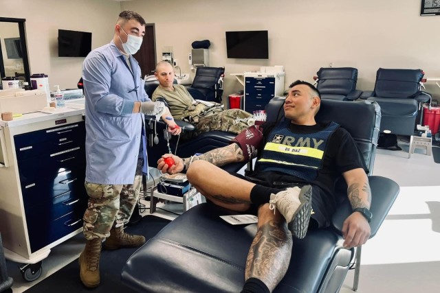 Spc. Isaac Noga, Fort Leonard Wood Blood Donor Center phlebotomist (left), talks with Staff Sgt. Christian Diaz and Pvt. Cesar Mosquera, with Company C, 787th Military Police Battalion, as they donate blood here on March 5.