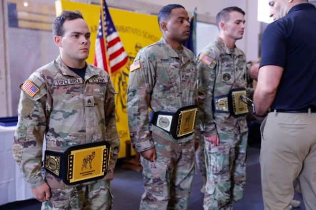 U.S. Army Soldiers receive a belt for winning first place at the Lacerda Cup at Sgt. 1st Class. Paul R. Smith Gym, Fort Benning, Georgia, April 13, 2023. The Modern Army Combatives Program builds mental and physical toughness and enhances unit combat readiness by training Soldiers in close-quarters combatives, instilling the warrior ethos and preparing Soldiers to close with and destroy the enemy in hand-to-hand combat. (U.S. Army photo by Pfc. Summer Parish/ 50 Public Affairs Detachment)