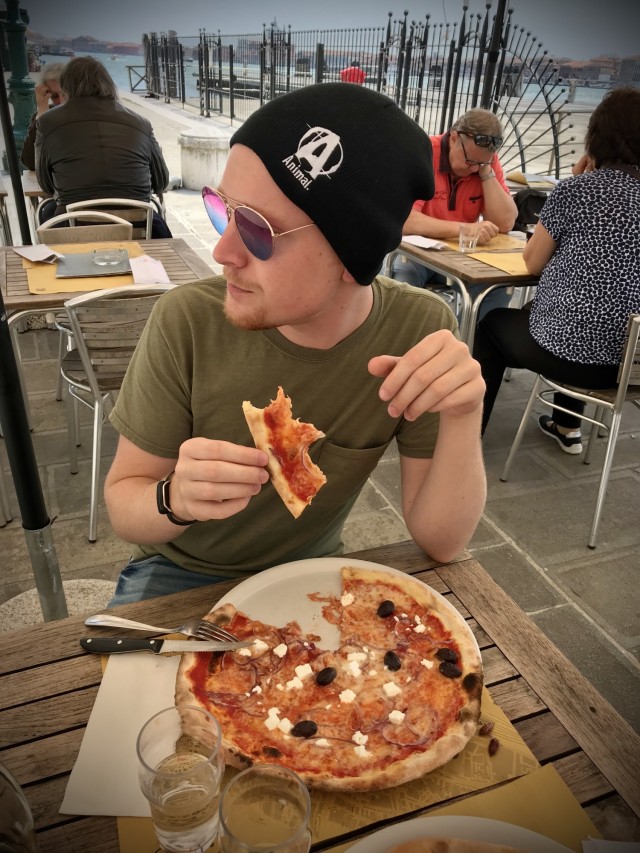 Ethan Flower, stepson of Sgt. Maj. Timothy Ferraro, Signal Leader Development College at Fort Gordon, Georgia, enjoys pizza on the canals of Venice, Italy.