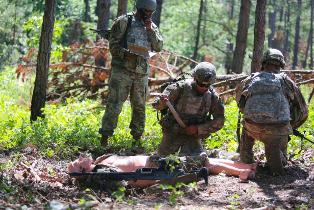 Soldiers apply first aid to a simulated casualty