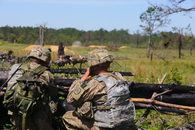 Soldiers surveil an objective down range