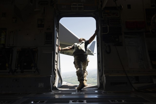 A Basic Airborne Course jumpmaster checks to see if the area is clear during a static-line jump from a C-130 cargo aircraft at Fort Benning, Georgia, March 30. The three-week course teaches service members from every military branch how to safely conduct airborne operations.