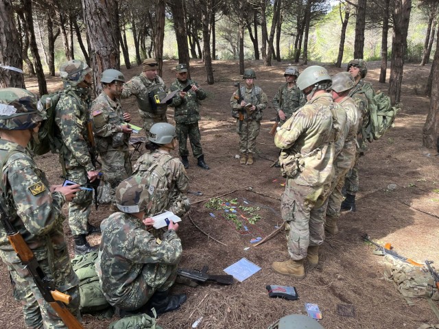 New York and New Jersey Army National Guard officer candidates and Albanian officer cadets listen during a mission briefing on April 12, 2023, near Rrogozhine-Kryevidh, Albania. The officer candidates participated in two weeks of training with Albanian officer cadets April 10-24 as part of a State Partnership Program exchange. 