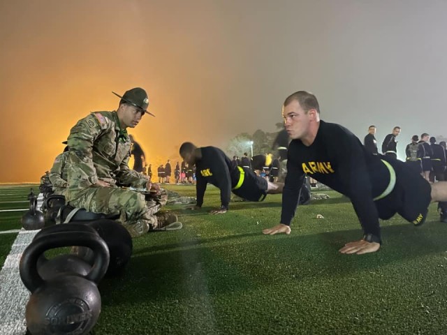 A drill sergeant grades a trainee knocks out push-ups during the Army Combat Fitness Test.