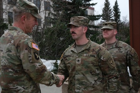 Chief of Staff of the Army, Gen. James McConville (left), presents a coin to Staff Sgt. Joseph Feola, 95th Chemical Company, 17th Combat Sustainment Support Battalion, at Joint Base Elmendorf-Richardson, during his visit to the 11th Airborne Division in Alaska, May 5, 2023. McConville recognized soldiers for excellence during his visit, including Feola for being on the two-person team that recently won the Army Best CBRN Competition, on the first stop of his tour of the Indo-Pacific to meet with partners and Allies in the region. (Photo by Staff Sgt. Michael Sword/11th Airborne Division PAO)