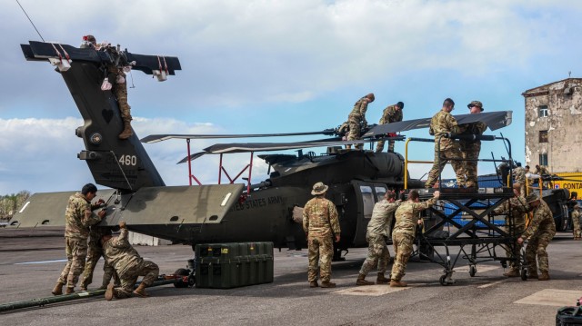 U.S. Soldiers assigned to the 3rd Combat Aviation Brigade, supporting the 4th Infantry Division, unfold the rotor blades on a UH-60 Blackhawk at the Port of Riga, Latvia, April 26, 2023. The 4th Infantry Division’s mission in Europe is to engage in multinational training and exercises across the continent, working alongside NATO allies and regional security partners to provide combat-credible forces to V Corps, America’s forward deployed corps in Europe. (U.S. Army photo by Spc. Williams Thompson, 1st Armored Division Combat Aviation Brigade)