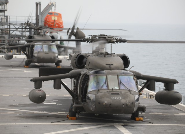 Two U.S. Army UH-60M Black Hawk helicopters assigned to the New York Army National Guard&#39;s 3rd Battalion, 142nd Aviation Regiment, Assault Helicopter Battalion, attached to the 36th Combat Aviation Brigade, conduct deck landings on the USS...