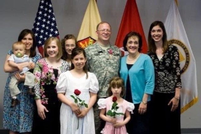 Thomas Cowan, pictured with his wife, their six daughters and one of their 11 grandchildren, on the day of his retirement from active duty service. 
