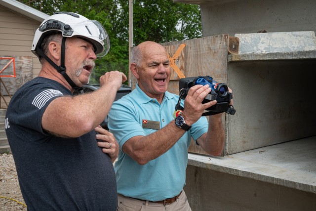 Dale Sanford (left), an Urban Search and Rescue Rescuer Course instructor here, discusses thermal imaging technology with Blair Shwedo, a civilian aide to the Secretary of the Army representing western North Carolina, on Tuesday during a tour of Training Area 235. Thermal cameras are used to look for fire behind walls or in adjoining rooms as well as searching for heat signatures in dark and smoky environments. About 100 CASAs, as they’re called, are here this week to attend their national conference. CASAs are business and community leaders appointed by the Secretary of the Army to advise and support Army leaders across the country. 
