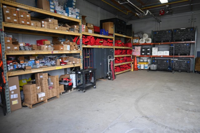 Shelves containing firefighting equipment are neatly organized.