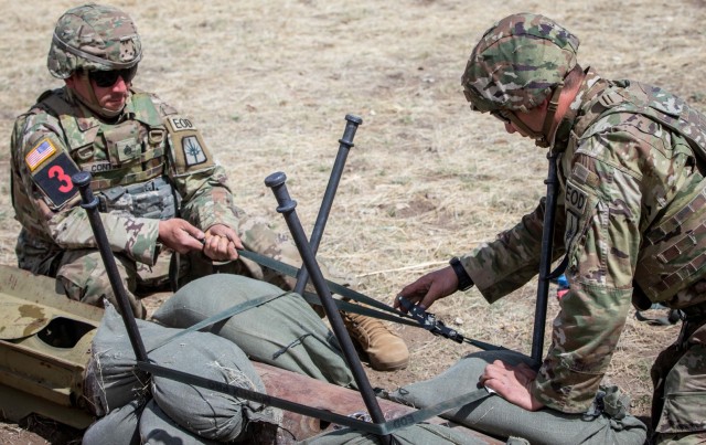New York Army National Guard explosive ordnance disposal technicians Staff Sgt. Robert Contini, left, and Sgt. Michael Wing, secure a Mark 82 general purpose bomb so it can be disarmed while competing in the All-Army EOD Team of the Year Competition at Fort Carson, Colorado, April 18, 2023.