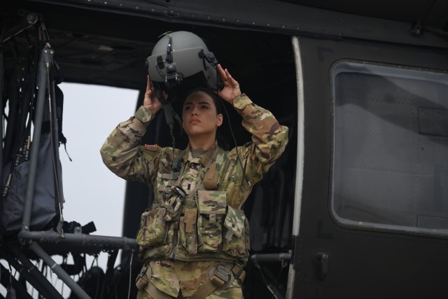First Lt. Georgia Cervantes, a UH-60 Black Hawk pilot, straps on her helmet at Fort Cavazos&#39; air Field on March 9, 2023. Cervantes was a dancer, swimmer and rugby player as a youth.
