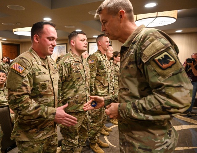 Gen. Daniel R. Hokanson, chief of the National Guard Bureau, presents a coin to Sgt. 1st Class Brandon Moseman in Saratoga Springs, New York, May 10, 2023. National Guard Bureau leaders recognized recognize recruiters for making New York the only state to exceed its recruiting goals for the year. (U.S. Army National Guard photo by SSG Matthew Gunther)