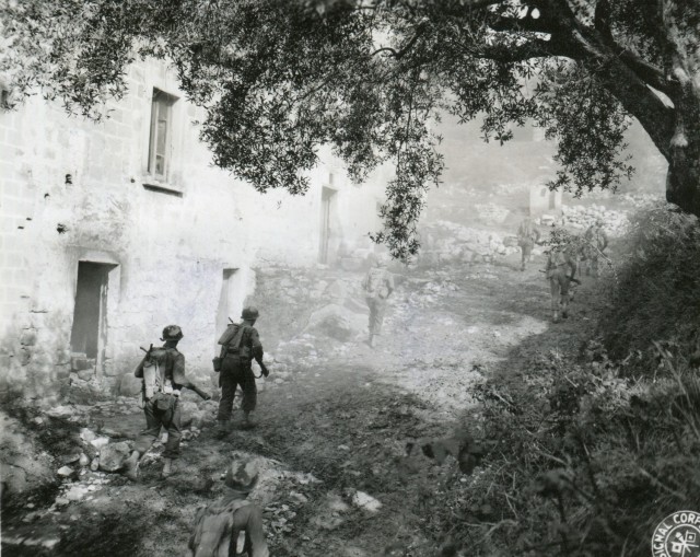 A rifle squad from 3rd Ranger Battalion passes a shelled-out dwelling in the Santa Maria sector of Italy on the route to the front line on Nov. 10, 1943. 