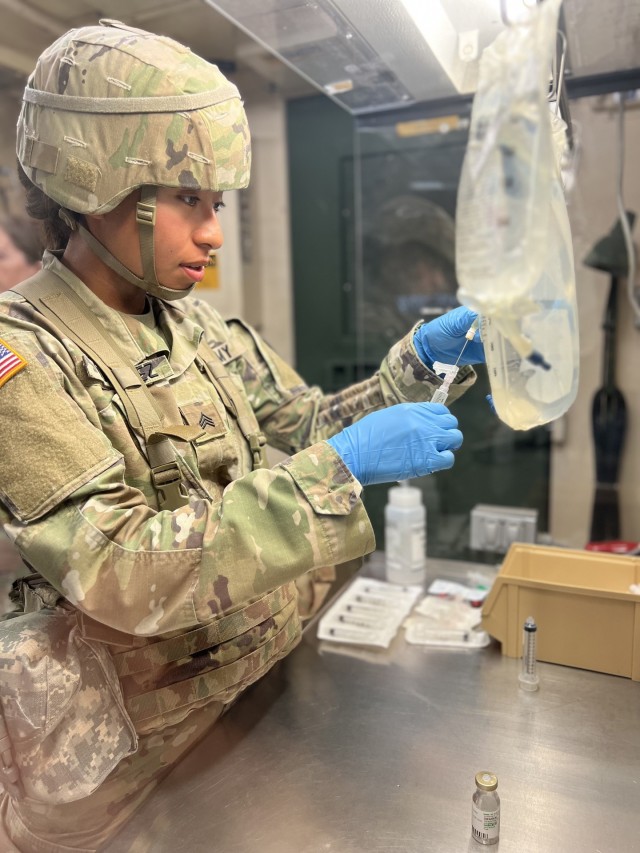 Sergeant Rachell Martinez-Juarez prepares an intravenous medication using aseptic technique for sterile compounding at the training field hospital in Camp Bullis, TX. Inpatient pharmacy tasks and skills are vital to timely and safe delivery of intravenous medications to critically ill patients in the battlefield. (Courtesy photo).