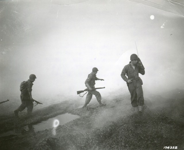 Under cover of smoke, a Ranger officer coordinates maneuvers via radio on the beach in Algeria on Dec. 20, 1942.  