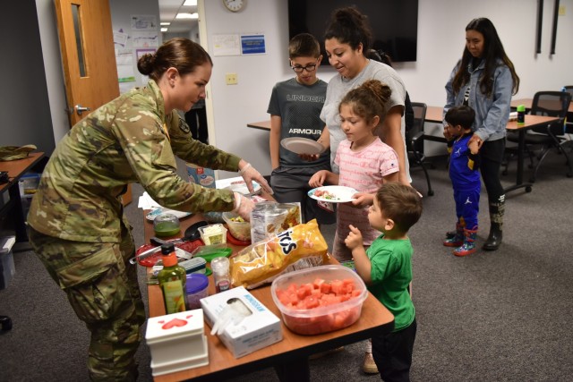 Capt. Cara Adams, chief of Outpatient Nutrition for the General Leonard Wood Army Community Hospital, serves mango salsa and watermelon salad after showing attendees of the Army Community Service’s Military Spouse Appreciation event on Friday how to make the healthy snacks during the Lesson from a Dietitian Class. 
