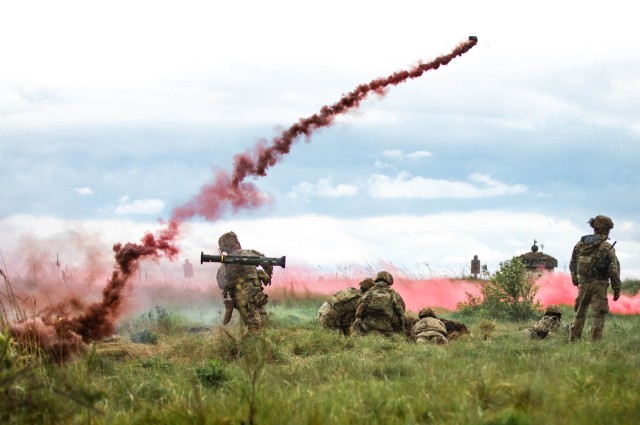 Photo of a soldier throwing a smoke grenade.