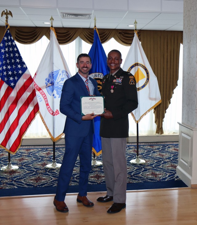 Mark Kitz, Program Executive Officer for Intelligence, Electronic Warfare & Sensors, presents the Legion of Merit to Col. Loyd Beal III for his accomplishments as the Project Manager for Terrestrial Sensors. 
