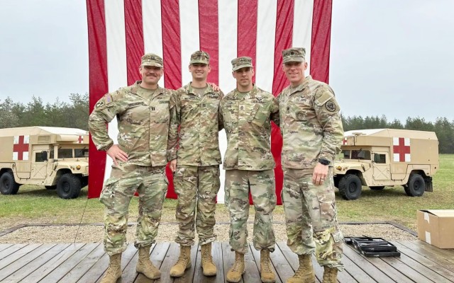 Sgt. 1st Class Talon Dumke, second from right, a combat medic assigned to the Wisconsin National Guard’s 54th Civil Support Team, with Lt. Col. Seth Kaste, right, 54th Civil Support Team commander, during the Expert Field Medical Badge ceremony May 12, 2023, at Fort McCoy, Wis. Dumke was one of eight Soldiers to complete the grueling competition, which challenged Soldiers in their technical proficiency and tactical acumen under extreme duress and scrutiny.