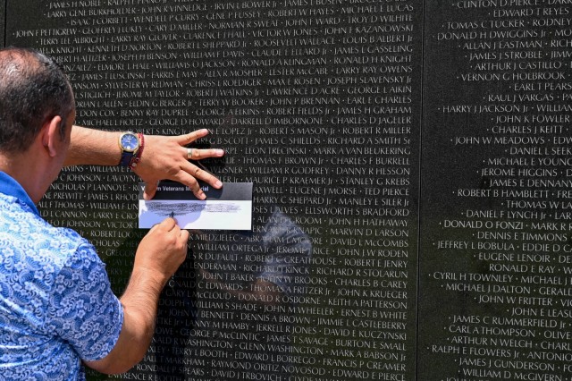 A visitor to the Vietnam Veterans Memorial in Washington, D.C. makes a graphite rubbing of one of the names on the wall March 11. The wall is inscribed with more than 58,000 names of those who were killed in action or are still missing in action. 