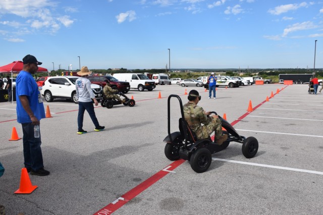 Soldiers try to navigate a short driving course using goggles that simulate being under the influence during the Safety Day event May 19, 2023, at the Phantom Warrior Stadium. (U.S. Army photo by Janecze Wright, Fort Cavazos Public Affairs)