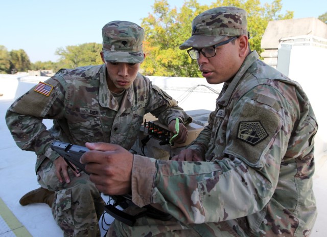 Specialists Mike Diep (left) and Matthew Scruggs of the 915th Cyber Warfare Battalion participate in a Field Training Exercise at Muscatatuck Urban Training Center, Ind., in October 2020. (Photo by Steven Stover)