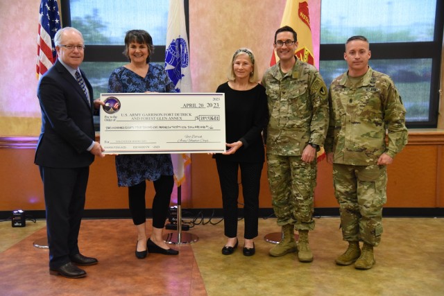 Joe Holland (left), deputy to the commanding general, U.S. Army Medical Research and Development Command, along with USAG Fort Detrick Commander Col. Ned Marsh and Command Sergeant Major Michael Dills, is presented with a check for the $284,936.81 in savings from our 126 registered volunteers in 2022.