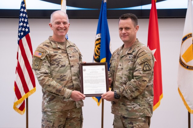 Col. Anthony Gibbs, left, receives the organizational charter from Brig. Gen. Christopher Schneider, Program Executive Officer (PEO) Soldier, assuming responsibility of Project Manager Soldier Warrior, during a change of charter ceremony held at...