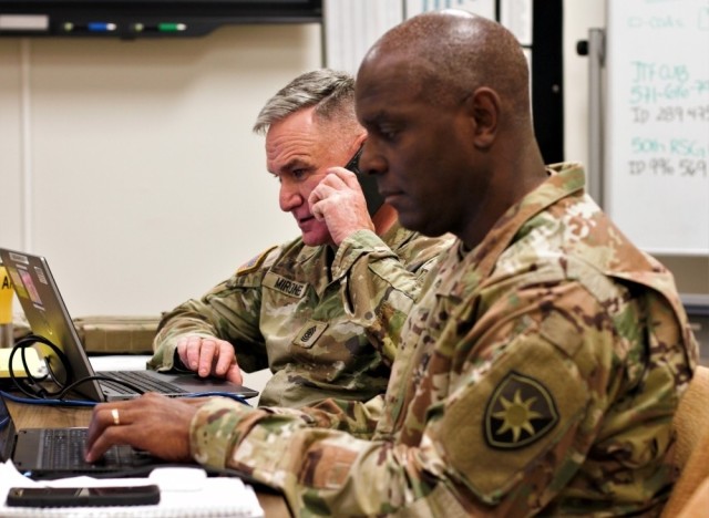 File Photo: Army Sgt. Maj. Gregory Mirones (left), senior operations noncommissioned officer, and Army Lt. Col. Craig Henson (right), operations officer, make final coordination for a unit’s placement during their activation for Hurricane Ian in Homestead, Florida, on Sept. 30, 2022. These Soldiers are members the Florida Army National Guard’s 50th Regional Support Group serving in the Homestead armory’s emergency operations center. (U.S. Army Guard photo by Sgt. 1st Class Shane Klestinski.)