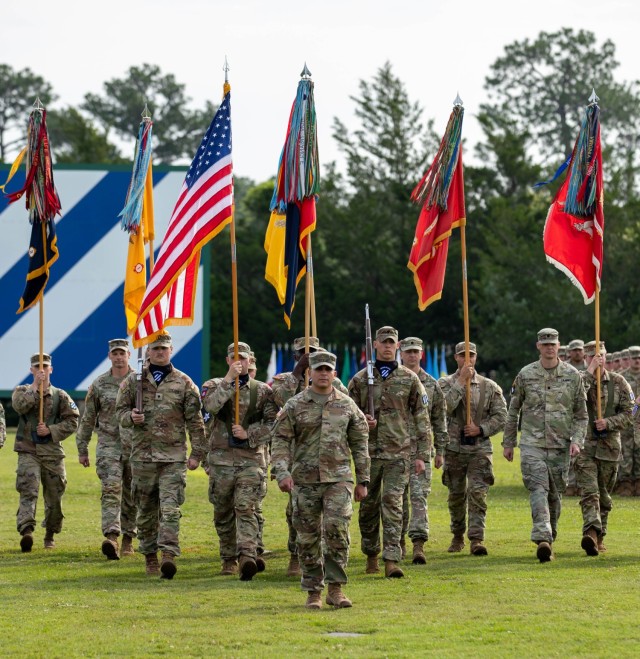 Command Teams and their colors march forward during the 1st Armored Brigade Combat Team change of command at Fort Stewart, GA on May 31, 2023. Commanders and colors marching toward the center of the marching field is a tradition where all the commanders and colors center on the formation during an event